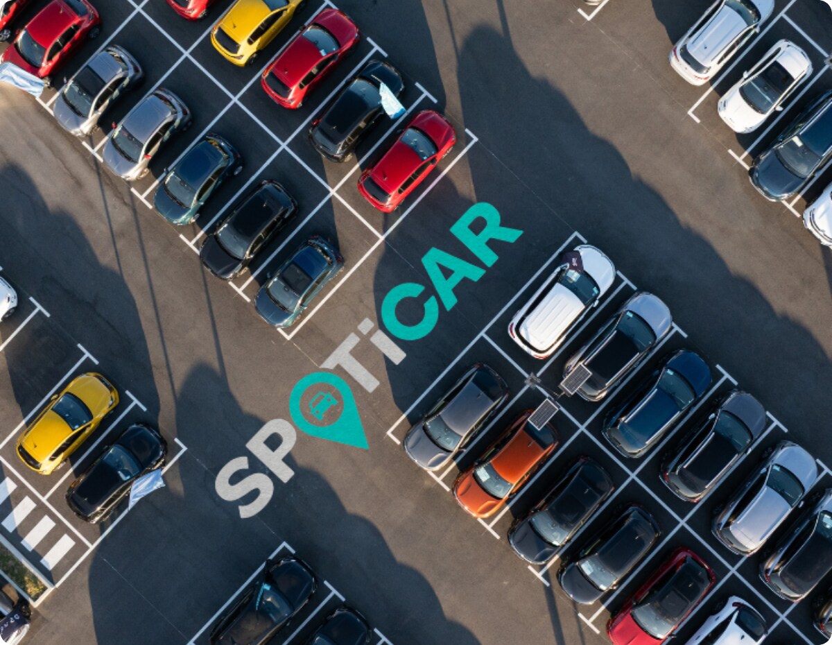 Luchtfoto van een parkeerterrein met meerdere voertuigen en Spoticar-branding, met nadruk op het aanbod goedgekeurde gebruikte Citroën-modellen.