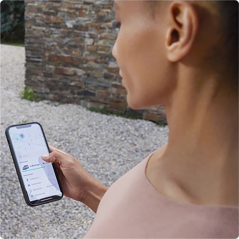 Persoon die een smartphone gebruikt om Citroën connected services te openen voor voertuigbeheer en functies op afstand.