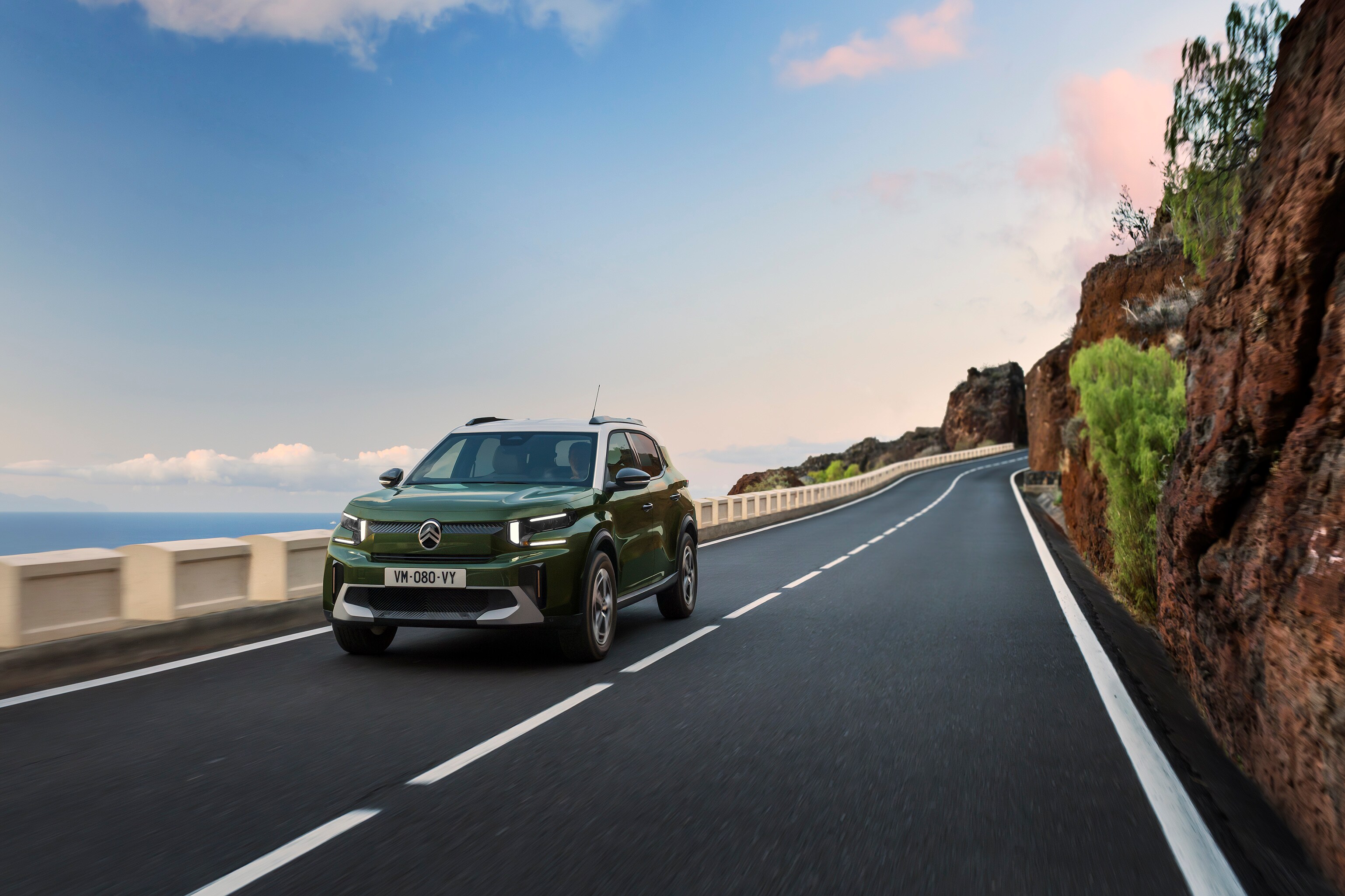 Driekwart achteraanzicht aan zee van de Citroën ë‑C3 Aircross elektrische SUV met bekroond design en 8‑jarige dekking voor betaalbare mobiliteit.