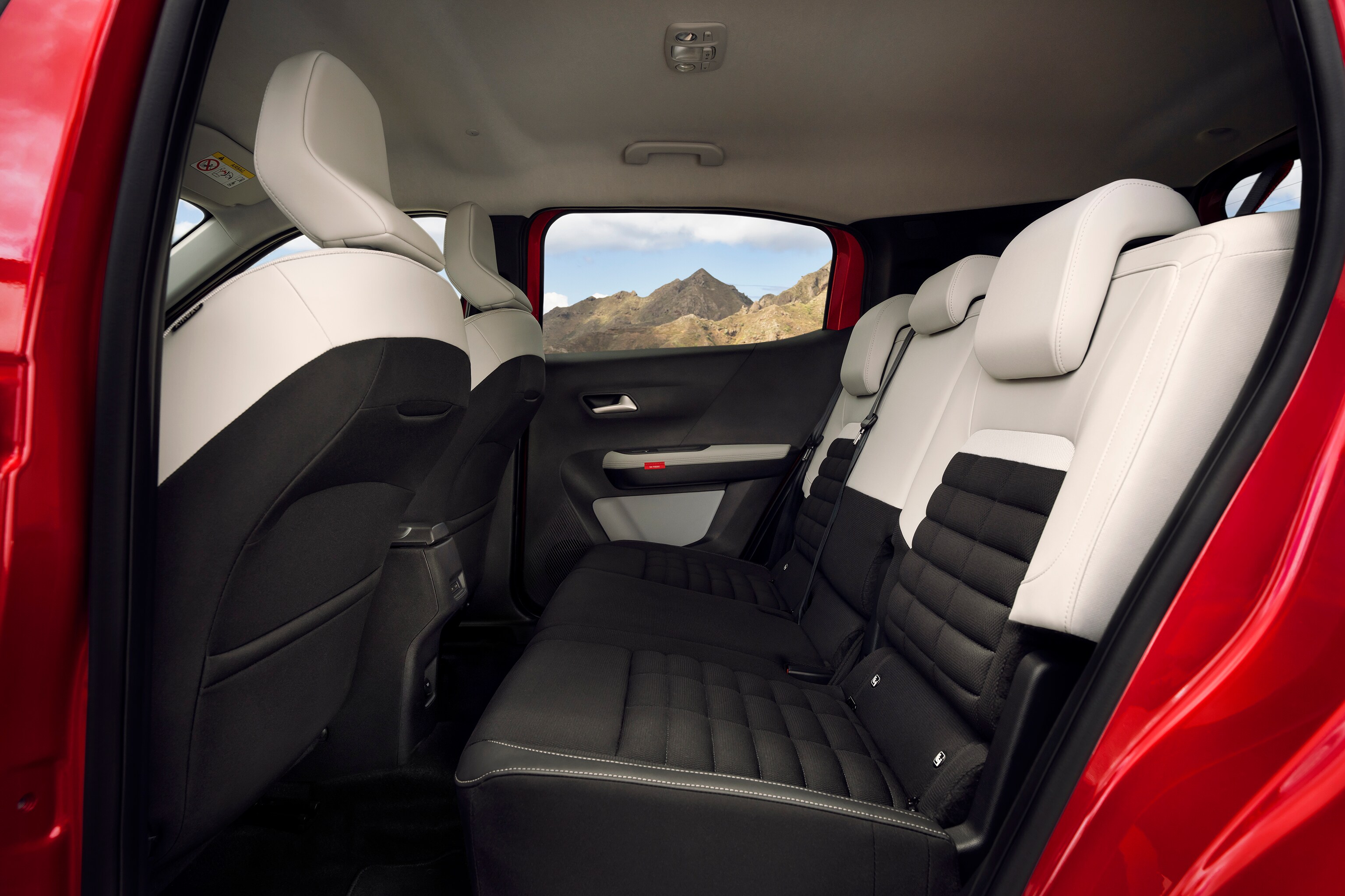 Achterbank van de Citroën compacte SUV met zwart‑witte bekleding en uitzicht op een berglandschap.